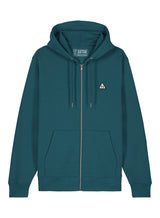 Sutsu Wylder Woven Badge Zip Hoodie - a teal organic cotton hoodie with embroidered sun and trees triangular badge logo.