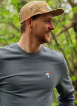 Man wearing a Sutsu Palm Tree EMB Slim Fit Sweatshirt - a green pullover sweatshirt with small embroidered palm tree and sun logo.