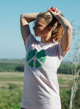 Woman wearing a Sutsu Peace Out T-Shirt - a white organic cotton, graphic tee with peace symbol and green leaves design.