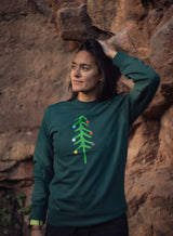 Woman wearing a green Sutsu Xmas Tree Slim Fit Sweatshirt - crew neck festive sweatshirts.