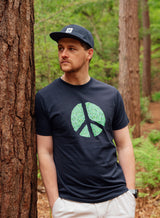 Man wearing a Sutsu Peace Out T-Shirt  - a black organic cotton, graphic tee with peace symbol and green leaves design.